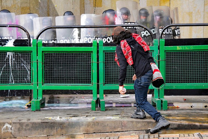 Manifestante protesta frente a la policía antidisturbios en la
