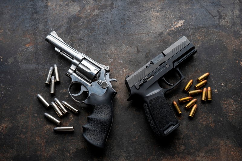Hand guns , ammo ,Guns with ammunition on Dark background.