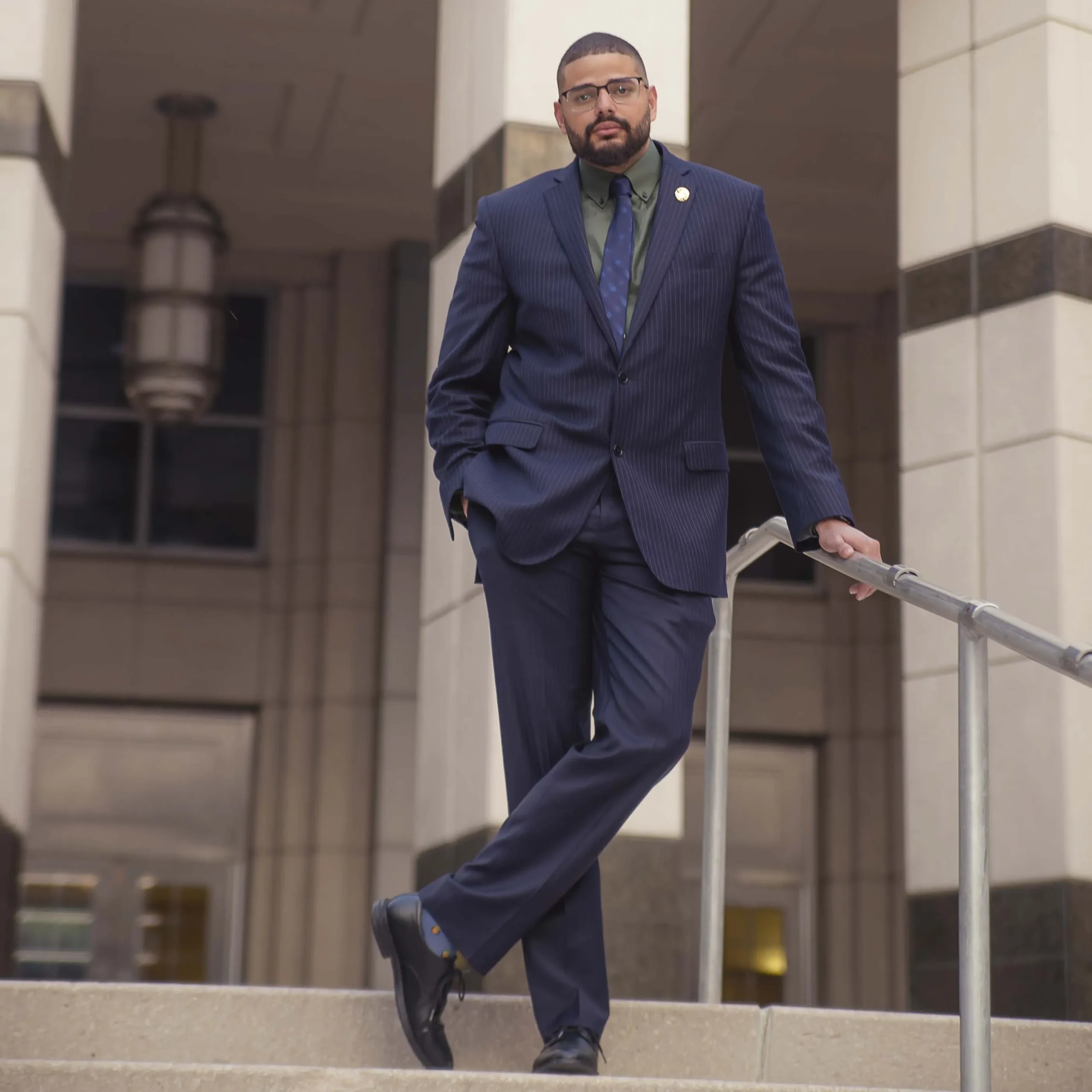 Professional man in a pinstriped suit standing confidently on outdoor steps